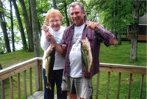 Man and woman holding fish.